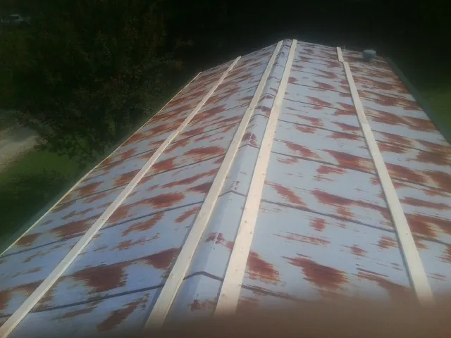Rusted metal roof panels with new wood purlins before replacement — Storm Damage Roof Repair in Conifer by Roofing Brothers